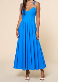Woman wearing a blue dress against a beige background