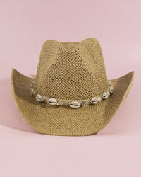 Beige cowboy hat with a shell band on a pink background