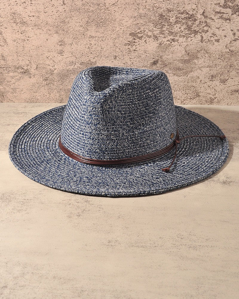 A woven fedora-style hat in a heathered blue-gray straw color with a brown band, displayed against a textured beige background.