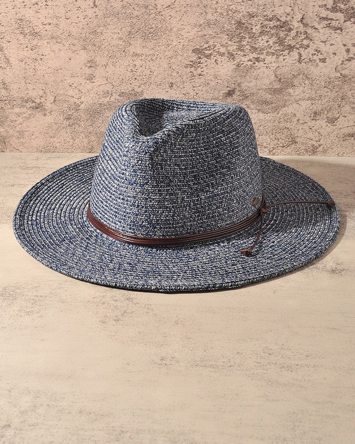 A woven fedora-style hat in a heathered blue-gray straw color with a brown band, displayed against a textured beige background.