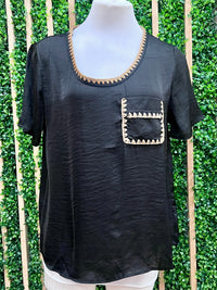 Black top with decorative whipstitch neckline and pocket front view.